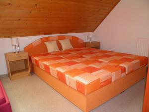 日亚尔普里瓦科娃卡娃酒店的一间卧室配有一张带2晚台的橙色大床