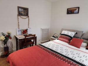 马恩河畔莱佩尔勒LES PINGOUINS DE LA MARNE的一间卧室配有一张床和一张桌子及椅子