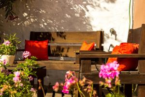马德普拉塔卡瓦尼亚斯波多冲浪度假屋的两张带红色枕头的木长椅和一些鲜花