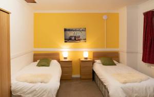 亨特利Dunedin House -Contractors - Business Travellers的黄色墙壁客房的两张床