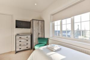 谢菲尔德Cosy, Exclusive, Sheffield House near Peak District by Ark SA的白色卧室,配有床和绿色椅子