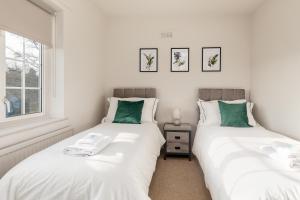 谢菲尔德Cosy, Exclusive, Sheffield House near Peak District by Ark SA的卧室内两张并排的床
