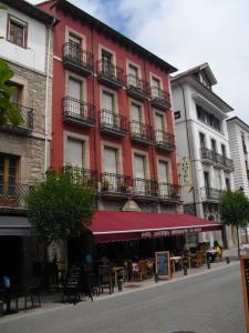 坎加斯-德奥尼斯罗斯罗布雷斯酒店的前面有桌椅的红色建筑