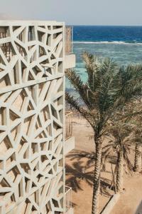 达哈布达哈布达尔公寓式酒店的棕榈树和海洋海滩上的建筑