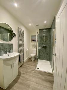 斯特灵Cosy Cottage的带淋浴、盥洗盆和卫生间的浴室