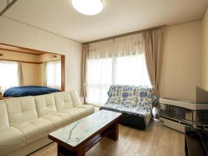 千岁LY INN CHITOSEAIPORT - Vacation STAY 94792的客厅配有沙发和桌子