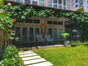 峇都丁宜Smell rose beach garden的一座带两把椅子的房屋和一座花园