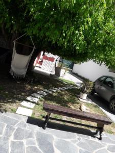 马德普拉塔Alojamiento Moni的木凳坐在树下的人行道上