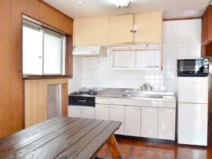 石垣岛Homa Ishigakijima no Yado - Vacation STAY 80173的厨房配有白色橱柜和木桌