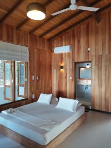 希克杜沃山波酒店和冲浪店的木墙客房内的一张大床