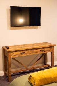 努盖特角The Salty Bushman B&B的木桌,墙上有电视