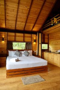 加姆波勒Riverbank Resort Gampola的卧室配有一张床铺,位于带木墙的房间内