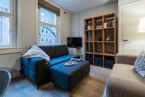 阿姆斯特丹Two-bedroom Apartment in Amsterdam West的客厅配有蓝色的沙发和凳子
