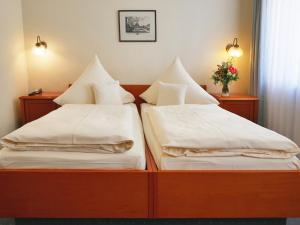 德累斯顿玛莎德累斯顿酒店的两张带白色床单和枕头的床。