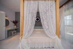 阿彻奇洛斯Sunset Apartments的一张带白色窗帘的天蓬床