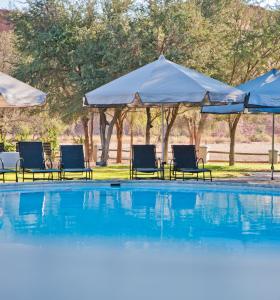 索利泰尔冈瓦纳纳米布沙漠小屋的一个带椅子和遮阳伞的游泳池