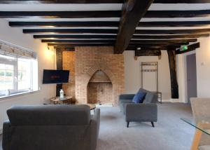达宁顿堡Donington Cottage Apt 8的带沙发和砖砌壁炉的客厅