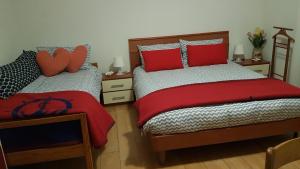 Quinto VicentinoB&B Kristina的一间卧室配有两张带红色枕头的床