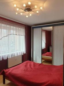 克莱佩达Klaipėdos miesto centras的一间卧室配有红色的床和镜子