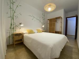 拉雷斯廷加Vivienda vacacional sur de europa b 3 4的卧室配有白色大床和植物