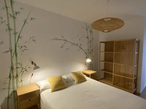 拉雷斯廷加Vivienda vacacional sur de europa b 3 4的卧室配有白色的床,墙上挂着植物