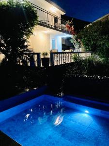 克拉西奇Apartments Obradovic的夜间在房子前面的游泳池
