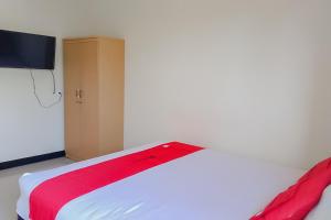 巴厘巴板RedDoorz At Pelangi Guest House的一间卧室配有一张床铺,床上铺有红色毯子