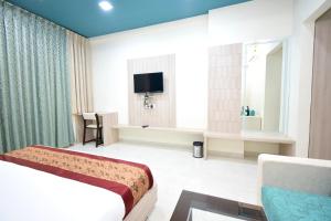 纳特杜瓦拉The Sky Imperial- Hotel Gopal Darshan的一间酒店客房,配有一张床和一台电视