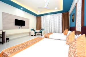 纳特杜瓦拉The Sky Imperial- Hotel Gopal Darshan的酒店客房设有两张床和一台平面电视。