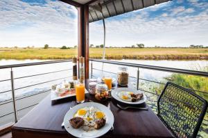 KongolaThe Namushasha River Villa的一张带早餐盘的桌子,享有河景
