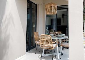 文蒂米利亚Ibiza style bungalows with sea views in Balzi Rossi的用餐室配有藤椅和桌子
