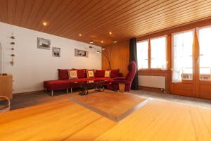 格林德尔瓦尔德史文迪波顿小屋公寓的客厅配有红色的沙发和桌子