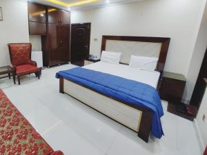 拉合尔Hotel White Pearl的一间卧室配有一张带蓝色毯子的床