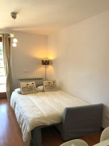 拉莫利纳Apartamento frente Pistas de Esquí La Molina的卧室配有一张带两个枕头的大白色床
