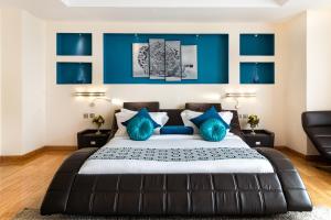 内罗毕PrideInn Azure Hotel Nairobi Westlands的一间卧室配有一张带蓝色枕头的大床