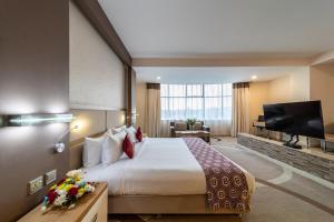 内罗毕PrideInn Azure Hotel Nairobi Westlands的配有一张床和一台平面电视的酒店客房