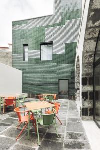 蓬塔德尔加达Casa da Galeria - Azores Art of Hosting的一组桌子和椅子,位于大楼前