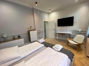 格但斯克Maya's Flats & Resorts 44 - Chlebnicka 17/18的一间卧室配有一张床、一张书桌和一台电视