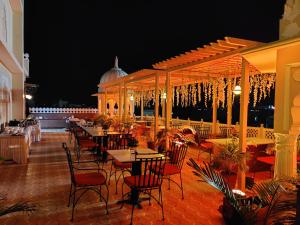 斋浦尔Laxmi Palace Heritage Boutique Hotel的晚上在庭院里设有桌椅的餐厅