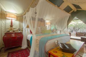 玛洛斯帕克Wielewaal Bush Lodge的一间帐篷内带天蓬床的卧室