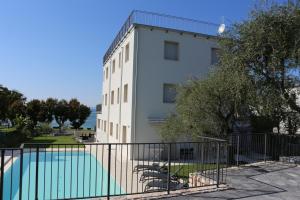 巴多利诺Residence VILLA ADRIANA的建筑前的一座带游泳池的建筑