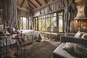 SinevrónArea Synest Nature Suites的一间卧室配有一张床、一张沙发和窗户。
