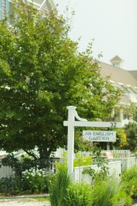 丹尼斯港英式花园酒店的房屋前有路标的白色十字架