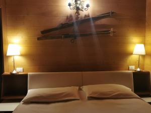 博尔查迪卡多尔Chalet nel bosco的卧室配有一张带两盏灯的墙壁床。