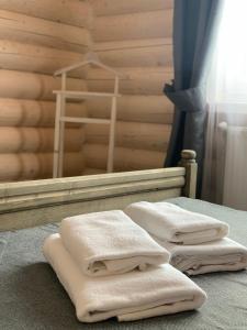 布克维Villa Olexandr&Matvii的三个白色毛巾坐在房间里的床边