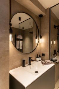 巴德加斯坦Residenz Boutique Suites的一间带水槽和镜子的浴室