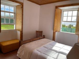 Pedro MiguelCasa do Bicho Pau的一间卧室设有一张床和两个窗户。