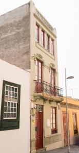 圣克鲁斯-德特内里费Mapango Small Rooms的一座带红色门和阳台的建筑