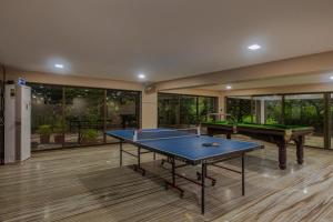 阿利鲍格SaffronStays Aura, Alibaug - luxury pool villa with a game room and spacious lawn的大房间,里面设有两张乒乓球桌
