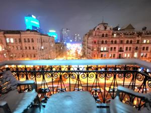 基辅Яркая история的阳台享有夜间城市美景。